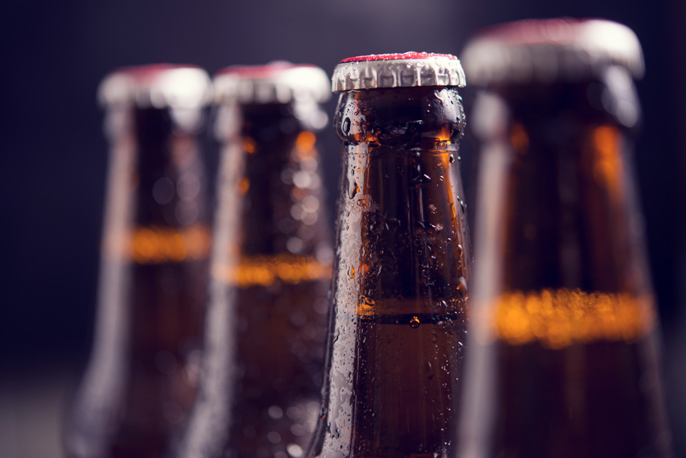 close-up-glass-bottles-beer-with-ice-dark-background